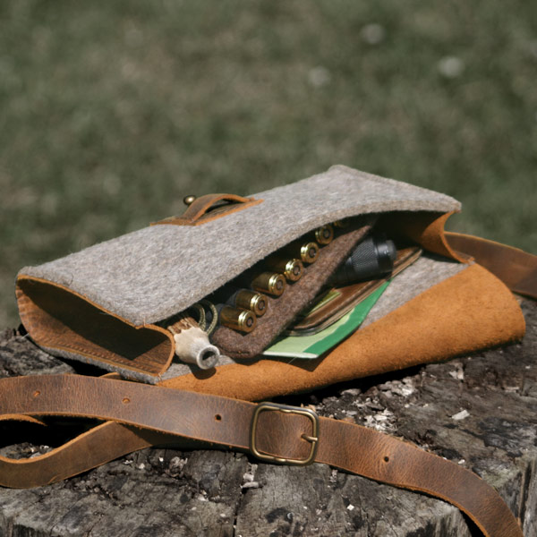offene Filztasche mit Inhalt liegt auf Boden