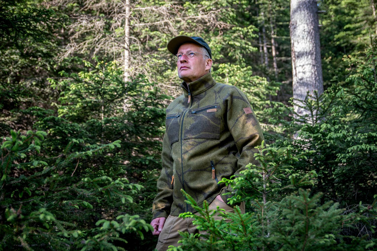Mann mit Tarnjacke in Dickung