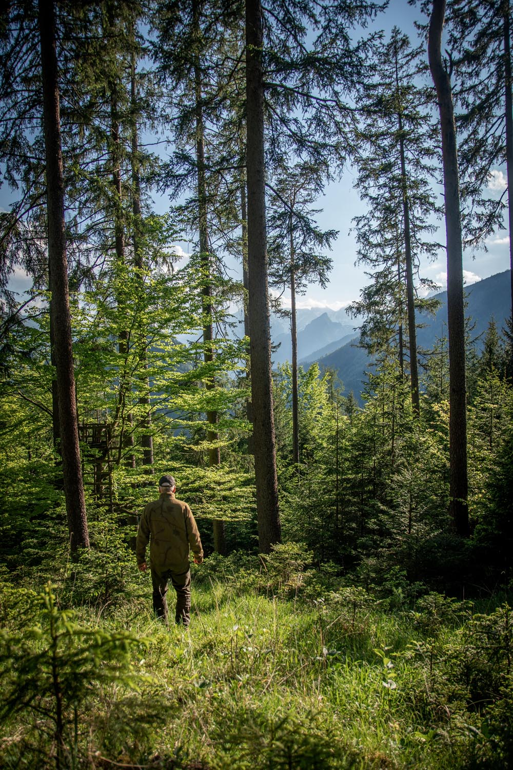 Jäger mit Tarnjacke verschwimmt im Wald